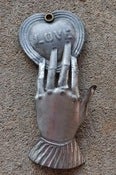 Image of Hand holding embossed Heart Milagro