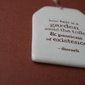 Image of ceramic quote tag - how fair is a garden