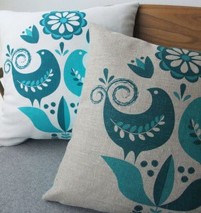 Image of happy birds cushion in teal and turquoise