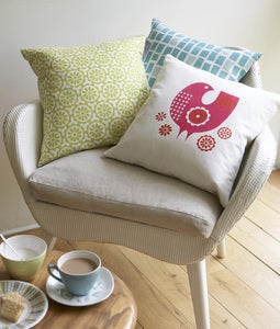Image of pink bird cushion on white linen