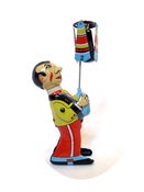 Image of Umbrella twirling Paya tin toy bloke with pointy face