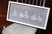 Image of 'Family Bicycles' framed papercuts on light grey by Hannah Greenwood.