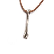 Image of silver femur bone on wax-coated cotton w/ silver caudal vertebrae closure (P01B10sil)