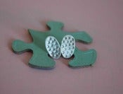 Image of oval silver studs, punched