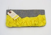 Image of a roundy-bottomed tough ruffles zipper purse in grey + canary