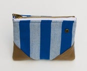 Image of a small blue-on-blue striped zipper pouch with leather corners and a METAL zipper