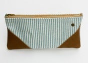 Image of a small aqua + cream striped zipper pouch with leather corners and a METAL zipper