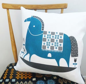 Image of rocking horse cushion in teal on white linen