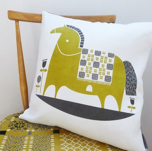 Image of rocking horse cushion in olive on white linen