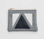 Image of small zipper pouch with geometric leather appliques and a metal zipper