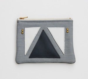 Image of small zipper pouch with geometric leather appliques and a metal zipper
