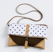 Image of foldover crossbody bag in vintage black + white polka dots with leather corners + tassel