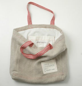 Image of Natural Linen tote bag with red hangers