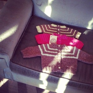 Image of hand knit baby sweaters