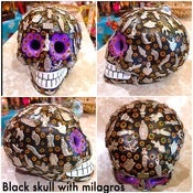 Image of Clay skulls with milagros